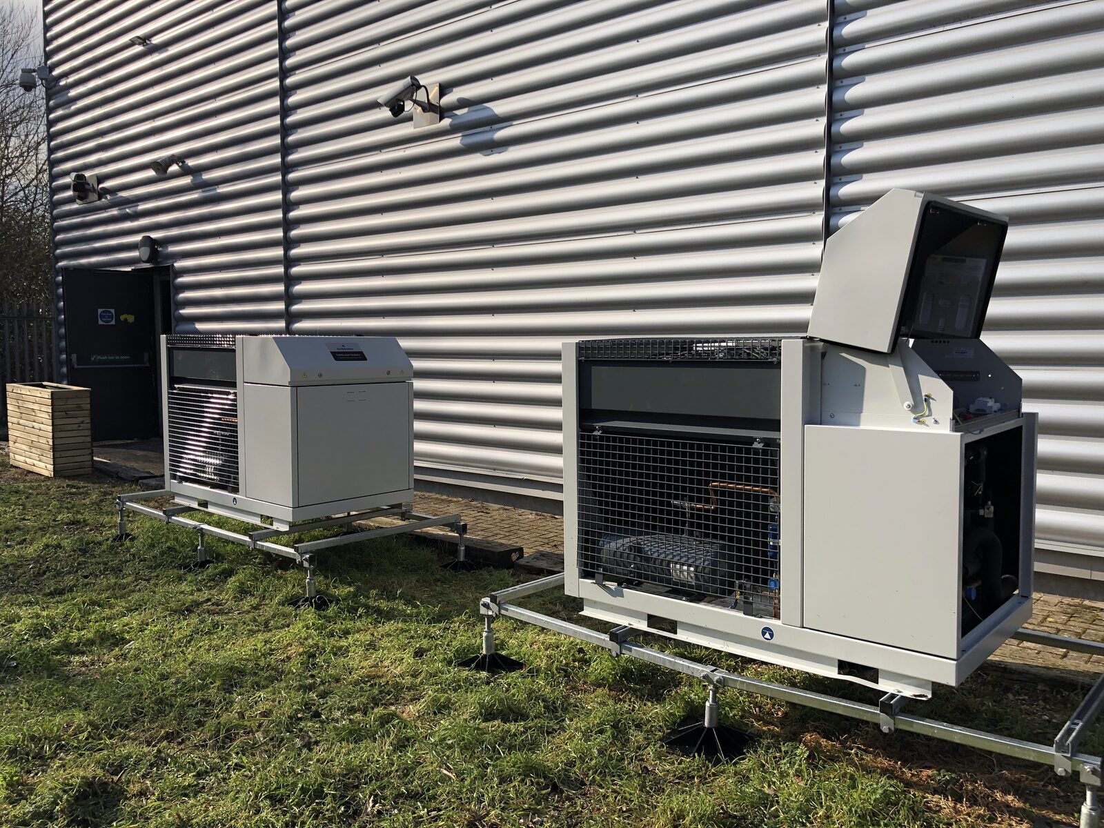Outdoor Condensing Units - Commercial condensing units on grass outside industrial building